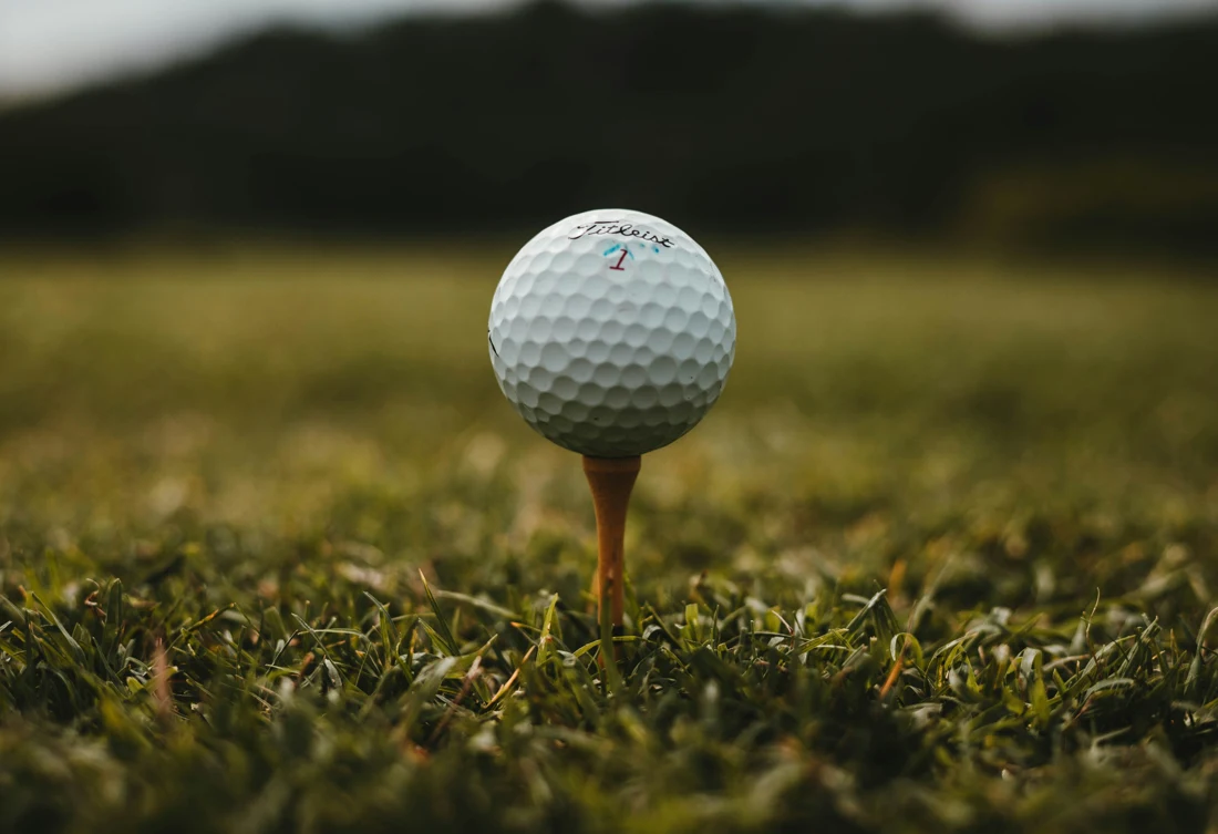 A golf ball on a tee in warm evening light